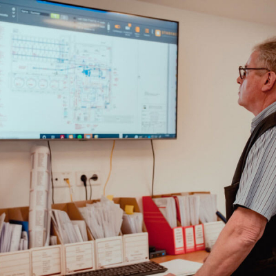 Mitarbeiter prüft Baupläne am Monitor