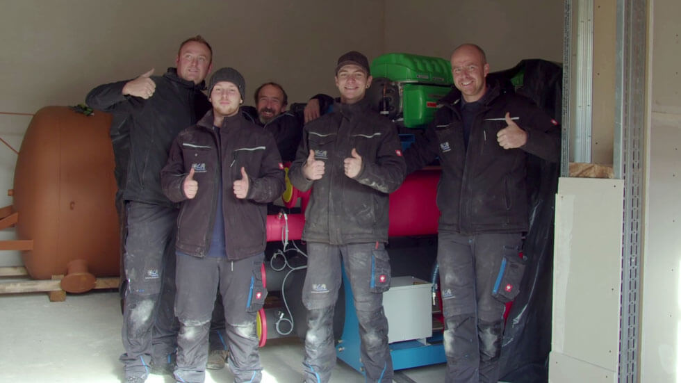 Gruppe von Arbeitern nach der erfolgreichen Installation der Anlage