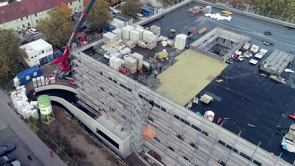 Drohnenaufnahme zeigt Kessel der mit einem Kran auf das Dach gebracht wird