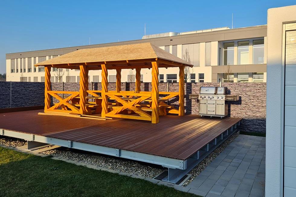 Grillhütte aus Holz mit Grill auf Firmengelände