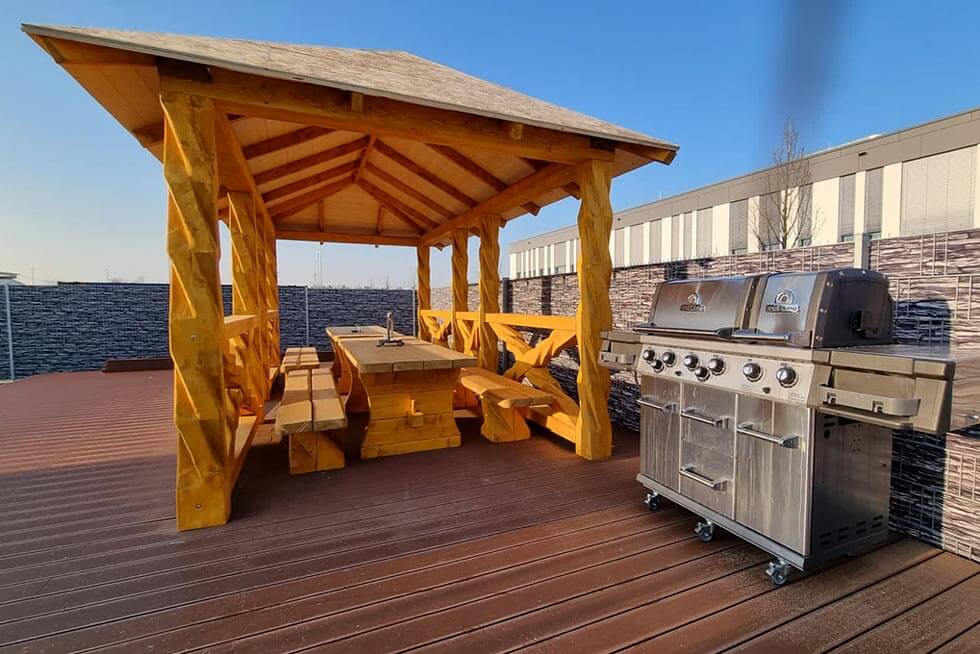 Grillhütte aus Holz mit Grill auf Firmengelände