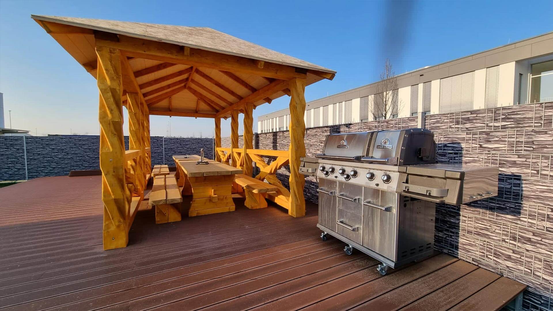 Grillhütte aus Holz mit Grill auf Firmengelände