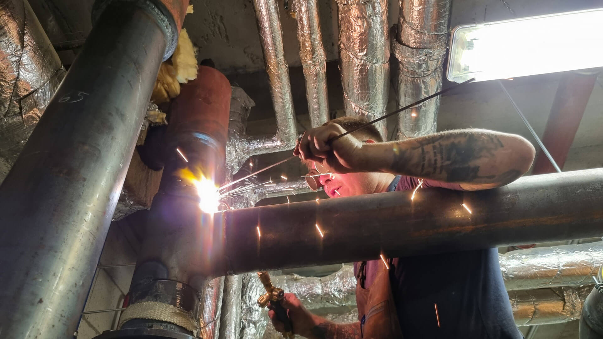 Arbeiter beim zusammenschweißen von Rohren