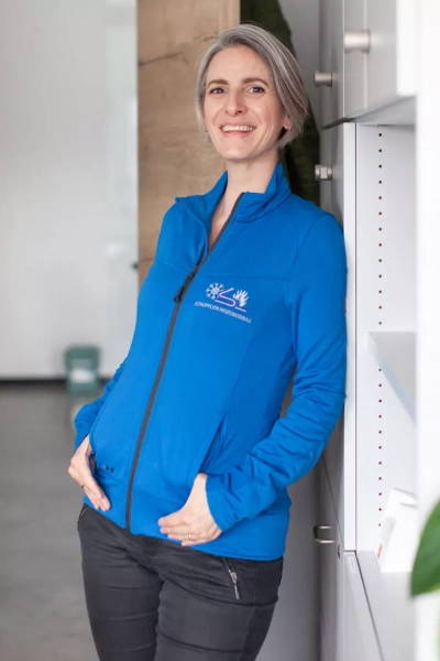 Foto einer Mitarbeiterin, die in die Kamera lächelt