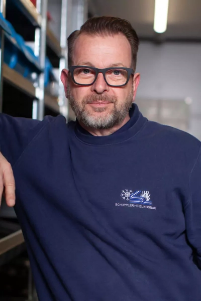 Foto eines Mitarbeiters, der in die Kamera lächelt