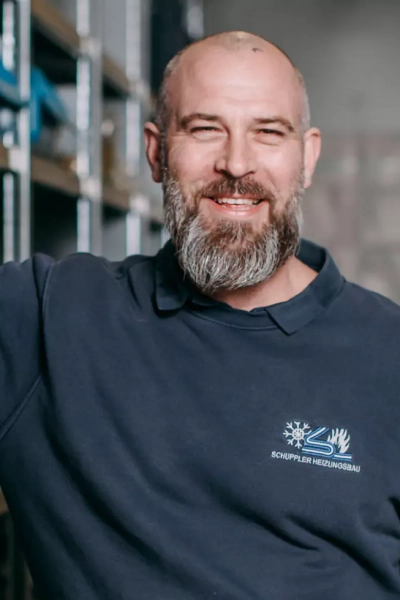 Foto eines Mitarbeiters, der in die Kamera lächelt