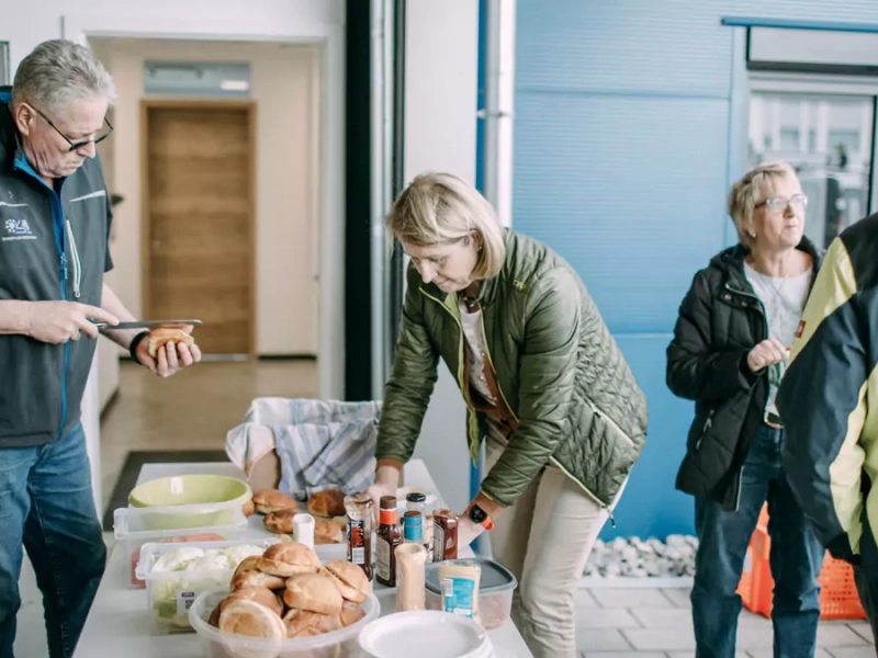 Teammitglieder versorgen sich an einer Essenstheke mit Essen