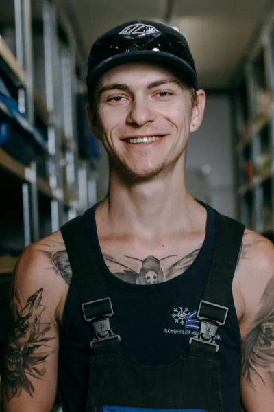 Foto eines jungen Mitarbeiters, der in die Kamera lächelt