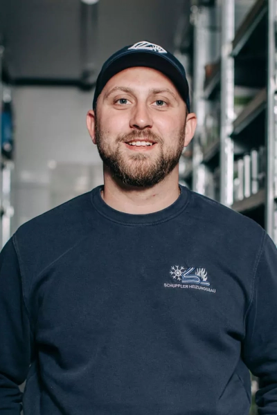 Foto eines Mitarbeiters, der in die Kamera lächelt