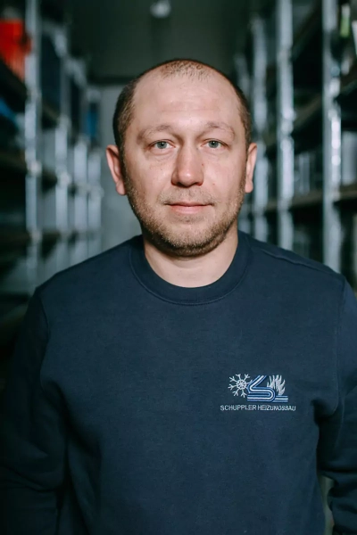 Foto eines Mitarbeiters, der in die Kamera lächelt